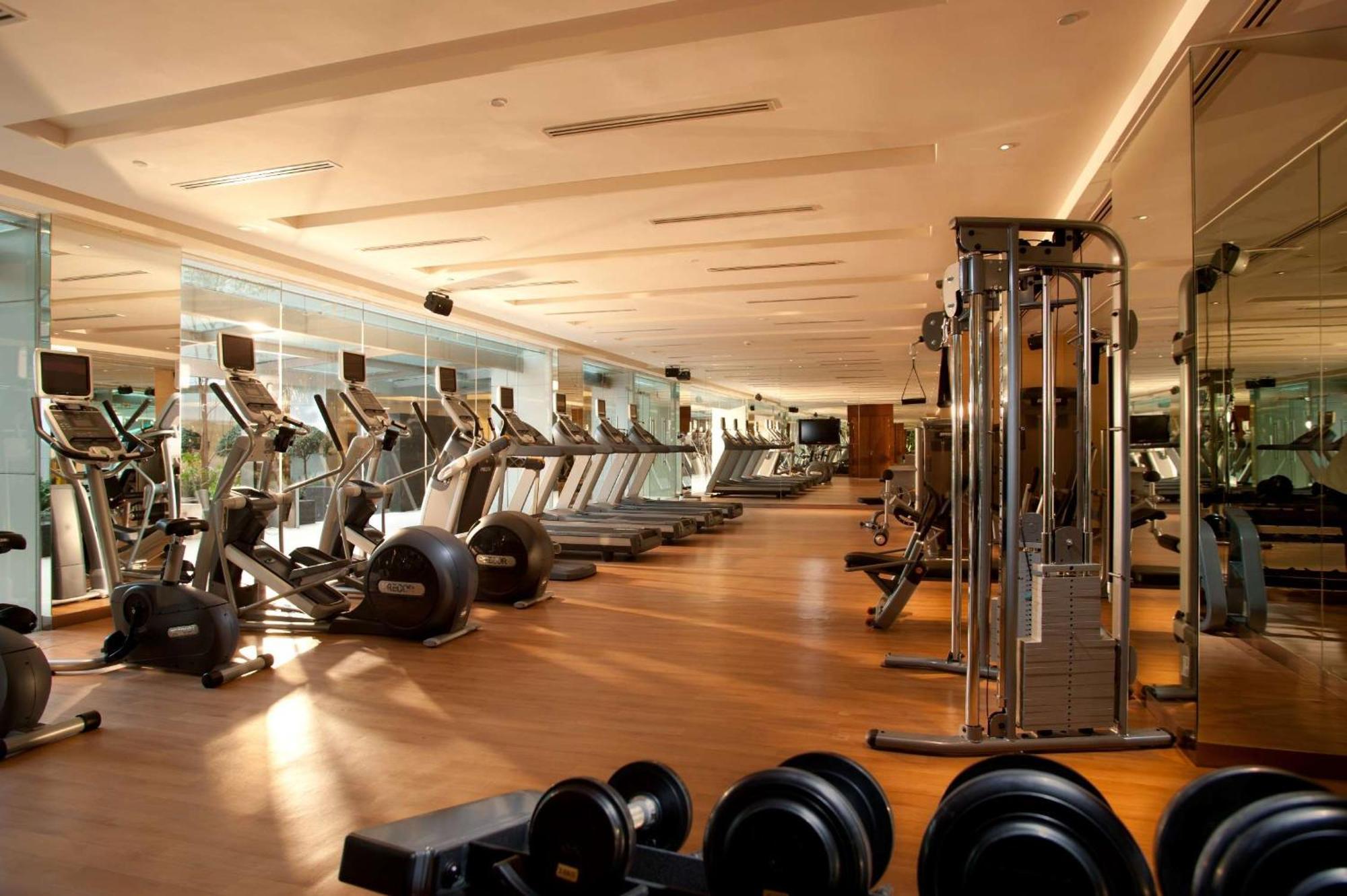 Doubletree By Hilton Kuala Lumpur Exterior foto The photo shows a modern gym interior. It features various fitness equipment including treadmills, exercise bikes, and weight machines. The gym has a spacious layout with large windows that allow natural light to enter, creating a bright and inviting
